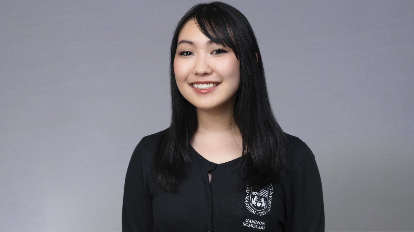 Portrait of Loyola University Chicago student smiling against gray background